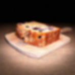 Slice of berry loaf cake on a wooden board