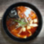 Bowl of spicy ramen with tofu and seaweed