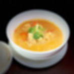Bowl of orange curry with vegetables and fresh cilantro
