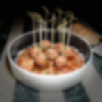 Meatballs in tomato sauce with skewers and bread slices