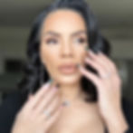 Nina Unrated with wavy dark hair, long nails, and silver jewelry.