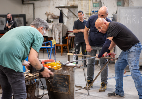 Many assistants are on hand to help the Master create the artisan glass vase. Photo by Kevin Maggiore.