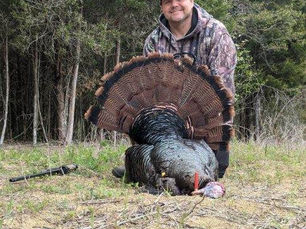 Hunter posing with a large Eastern wild turkey harvested during a spring hunt in Hamblen County, Tennessee.