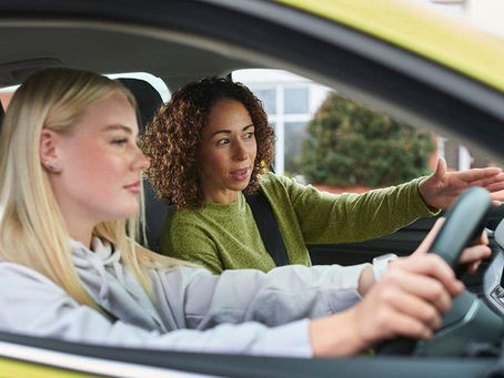 A young blonde female pupil and a female driving instructor.