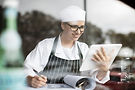 smiling-woman-in-workwear-with-clipboard-and-table-2024-09-21-17-53-27-utc.jpg