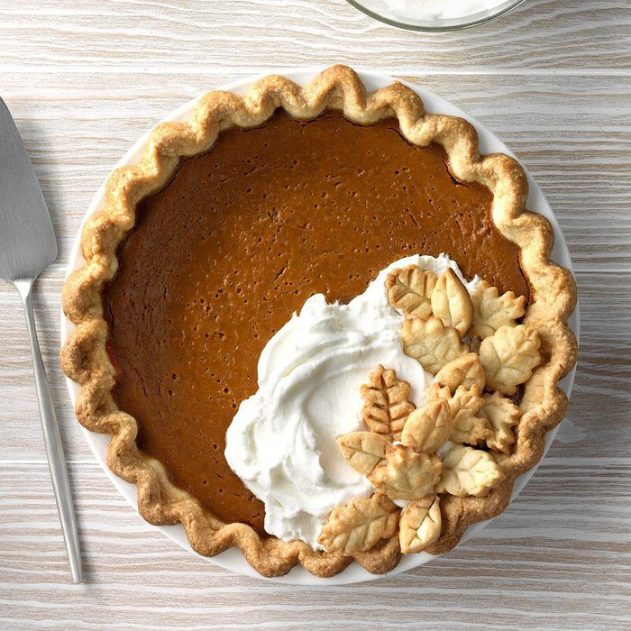 gingerbread pumpkin pie adorned with pie dough leaves and whipped cream