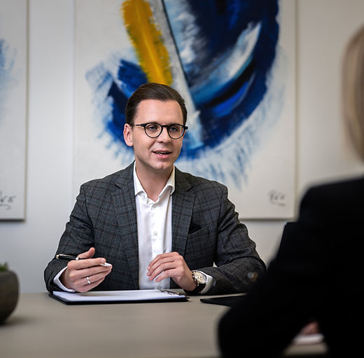 Daniel Wagner vor blauem Bild in einer Gesprächssituation