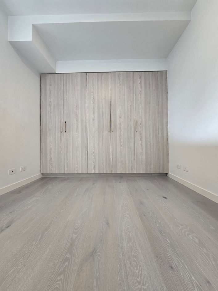 a room with grey timber flooring and grey wardrobe