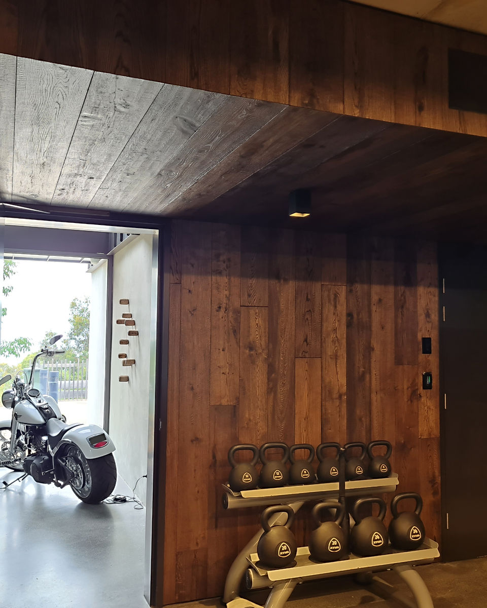 a gym room with bell weights and a doorway, a motocycle is visible from the doorway