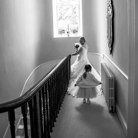 Bride descending staircase with flower girl before wedding ceremony