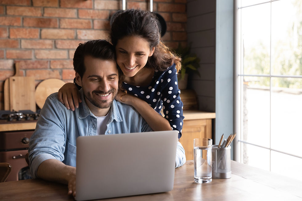 Happy millennial wife giving support to husband working at laptop from home, touching shou