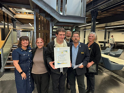 shine on award recipient kirk mercuri surrounded by a group of Rotarians and his mother