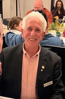 Gary in a blazer and shirt smiling.