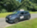 open road car with grass and trees
