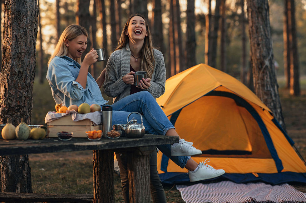 Two women laughing while tent camping