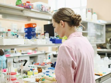 mujer en laboratorio mirando al microscopio