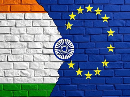 India and EU flags painted on a brick wall. Indian tricolour on the left, EU stars on a blue background on the right, blending in the center.