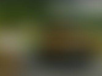 Bright yellow SUV driving on a winding road through a green, mountainous landscape.