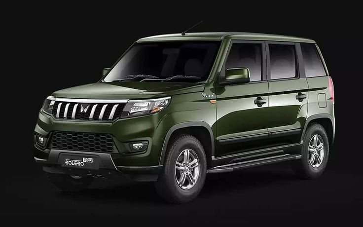 A dark green Mahindra Bolero is parked against a black background, showcasing its sleek design and silver wheels. Text on the grille reads "Bolero Neo."