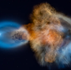 Colorful cosmic nebula with blue and orange gas clouds swirling in space against a starry black background.