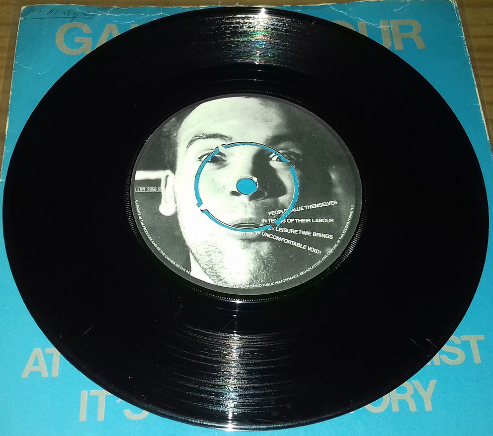 Miniatura: Gang Of Four - At Home He's A Tourist / It's Her Factory (7", Single) (EMI)