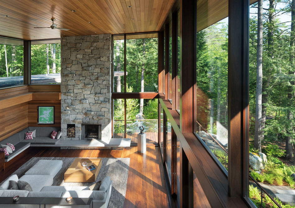 Second story view into two story living area in luxury home. Bright and sunlit living space made of cedar.