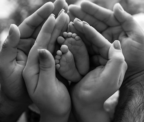 Mum and dad holding baby's hands
