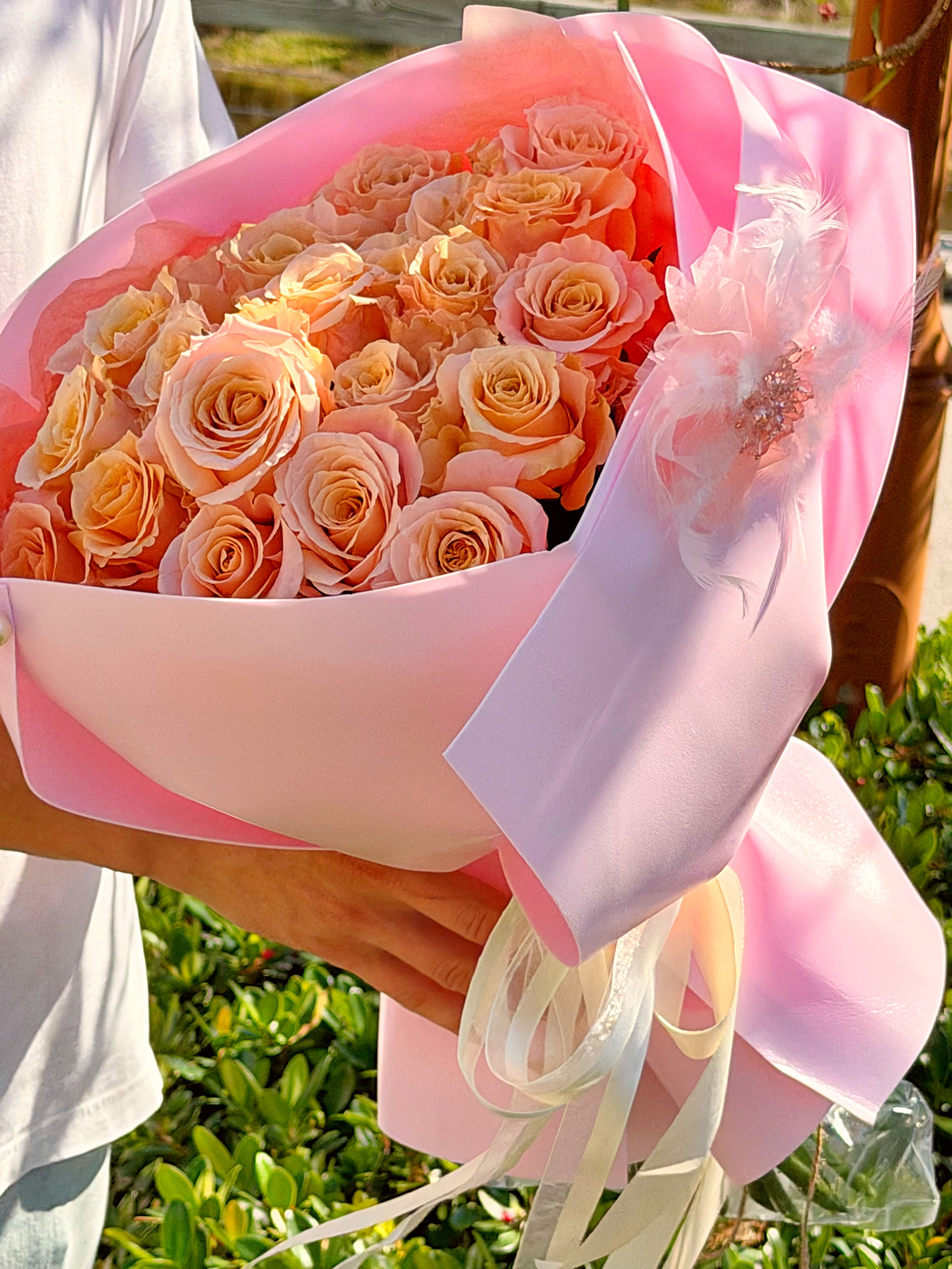 Luxury bouquet of 25 peach roses wrapped in blush pink paper in Naples Florida