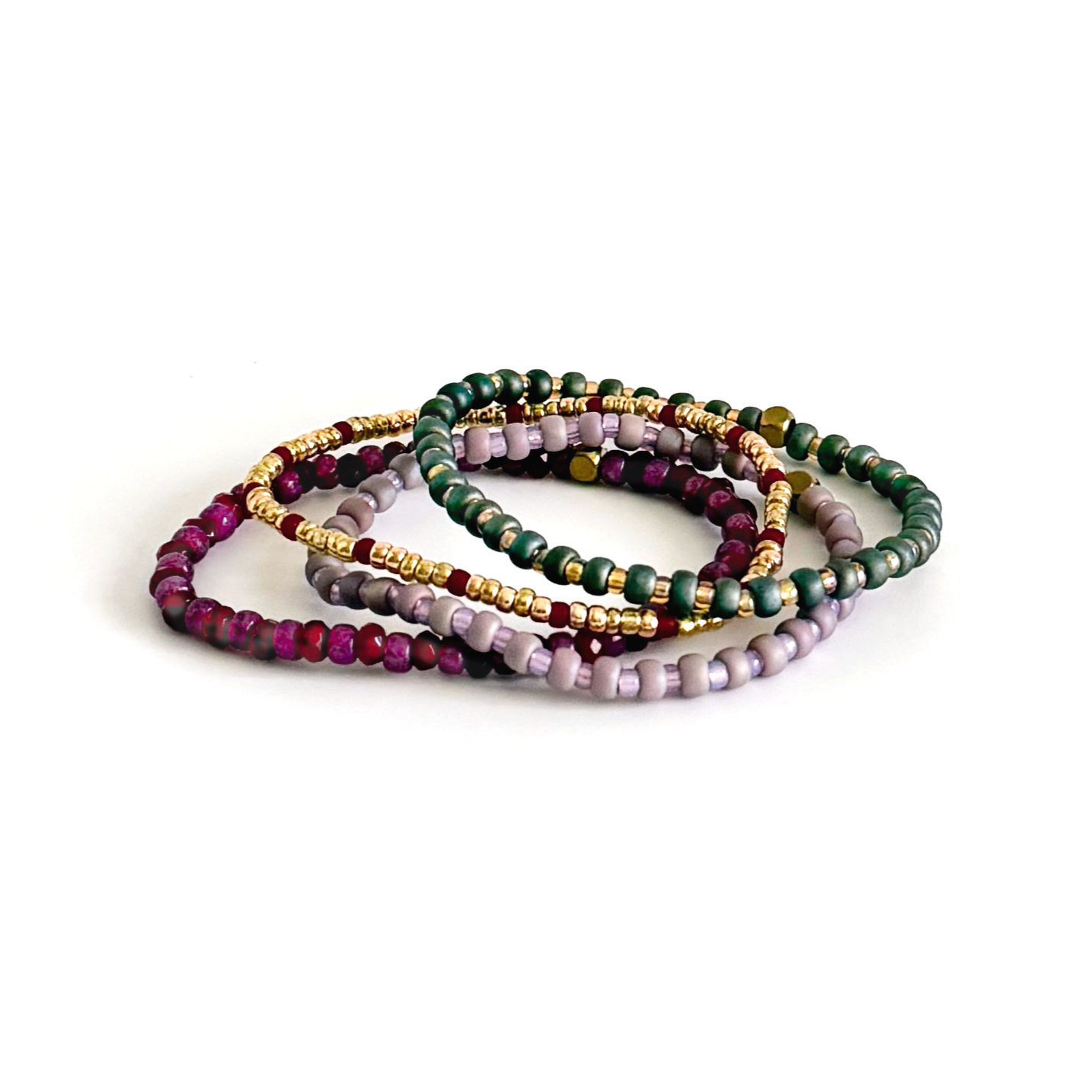 Four plum-toned beaded bracelets stacked