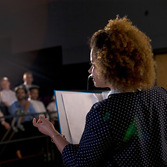 Professional woman addressing auditorium in a school