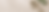 a white soft tailor's tape measure coiled on a textured beige surface alongside green leaves