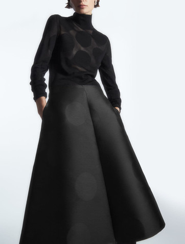 Model wearing skirt with big polka dot jacquard pattern. 