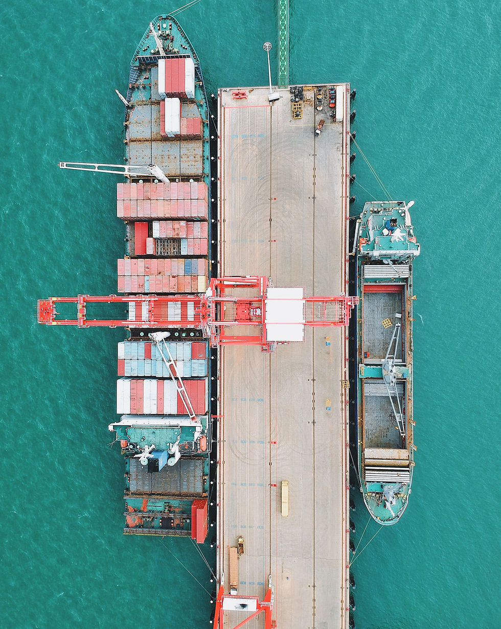 Aerial view of a cargo port with ships and containers on turquoise water