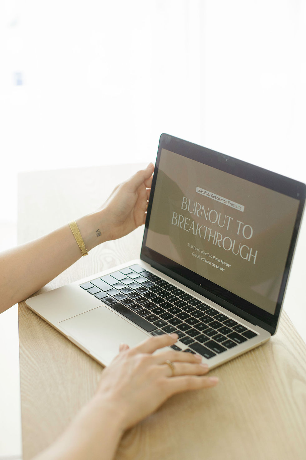 Close-up of a hand reaching toward an open laptop screen