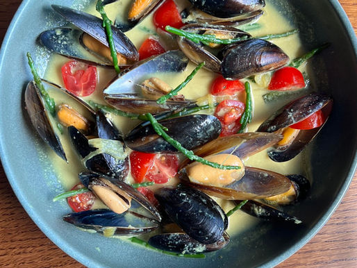 A vibrant plate of muscles, cherry tomatoes, and samphire in Sri Lankan Coconut sauce.