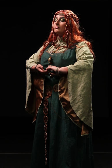 A noble woman posed formally wearing a green gown