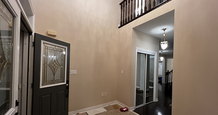 Before and after photos capturing a foyer makeover, revealing an elegant transformation with upgraded lighting