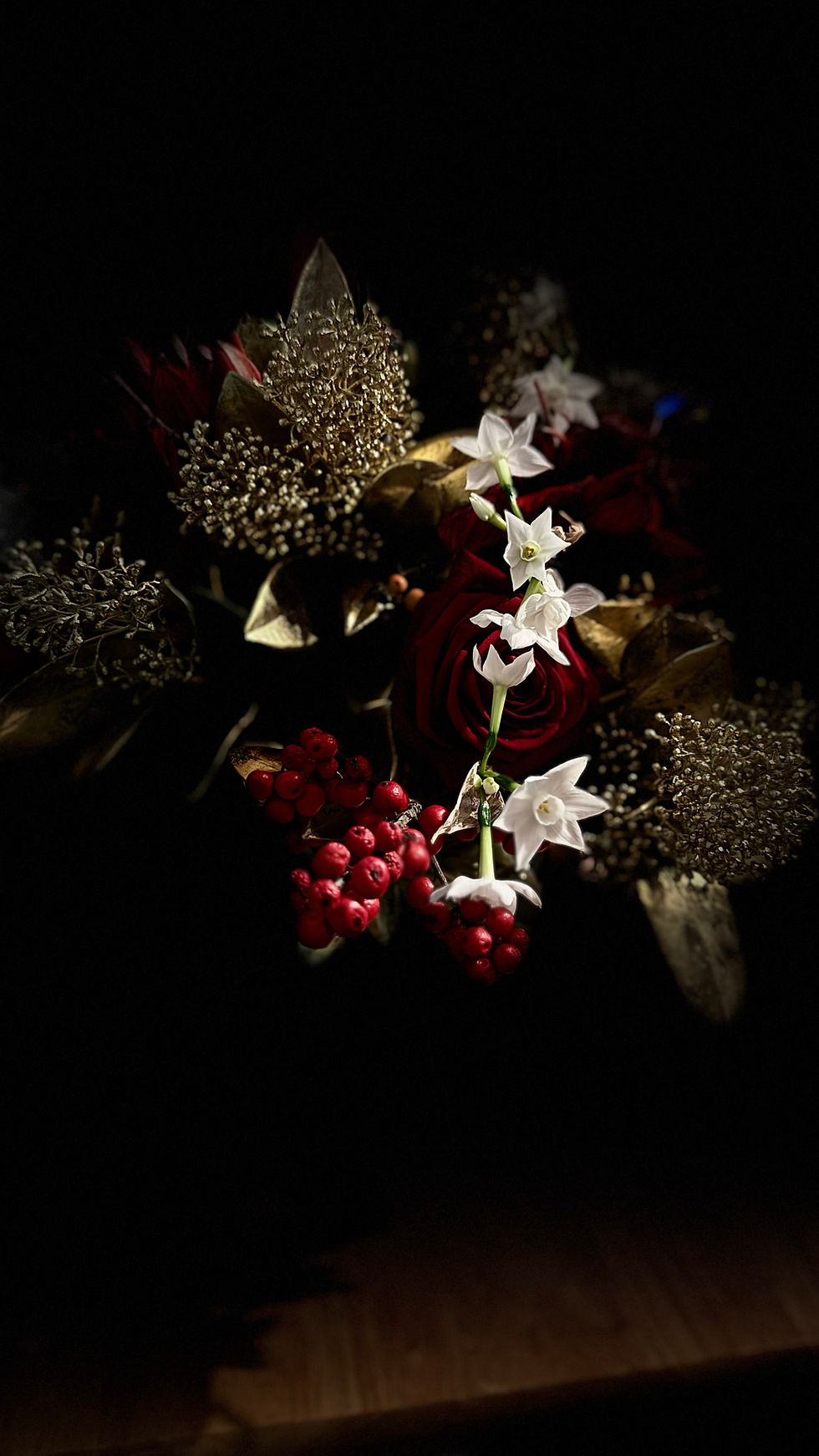 image of red roses, paperwhites, gold skimmia and ilex berries