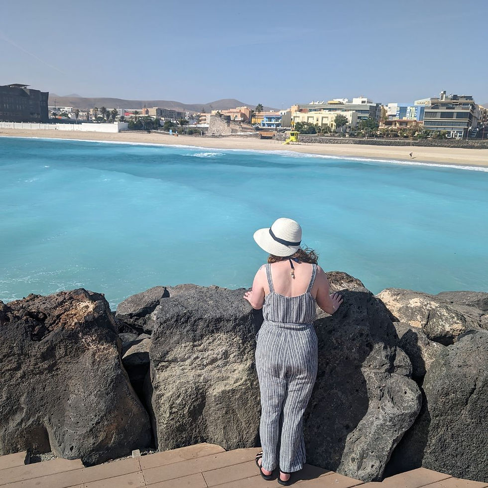 Photo of Lisa standing on a promenade looking out to sea