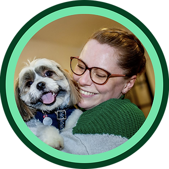 Profile photo of Lisa on the right wearing glasses, her hair is up and back from her face. Lisa is holding a small dog called Pan who is a shih tzu crossed with a toy poodle and his face is on the left. The image is ringed with a light green circle, then a dark green circle, in Silvertongue colours.