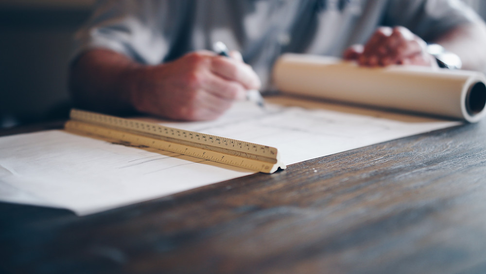 a builder write with pen on architectural plans