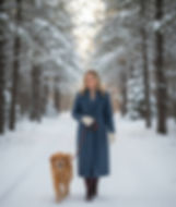 woman walking dog on snowy trail