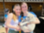 Two women holding adorable white puppy
