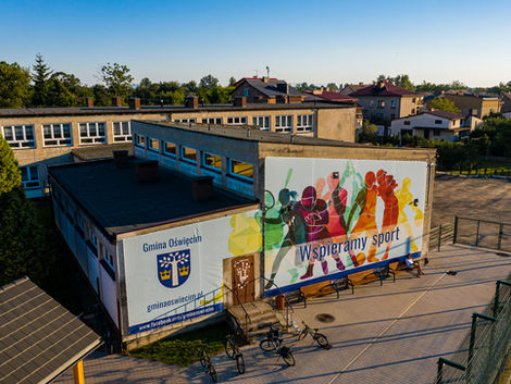 mural „Wspieramy sport” na budynku szkoły w Babicach w gminie Oświęcim kolorowa grafika na elewacji