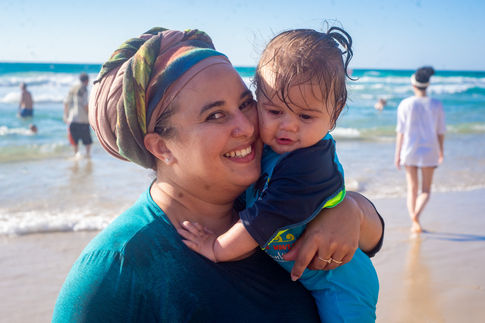A mom hugging her little son at the beach