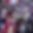 Close up photo of a microphone with a crowd of people in the background
