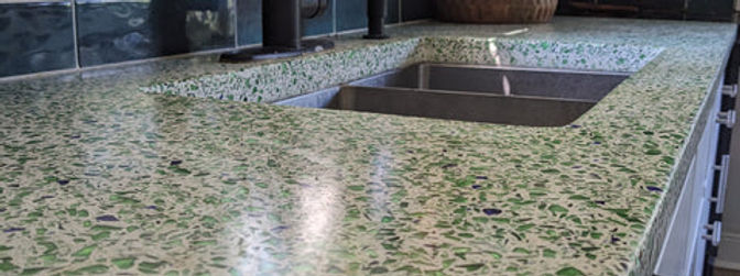 Glass and Stone aggregates added to concrete mix and revealed with wet polish pad.