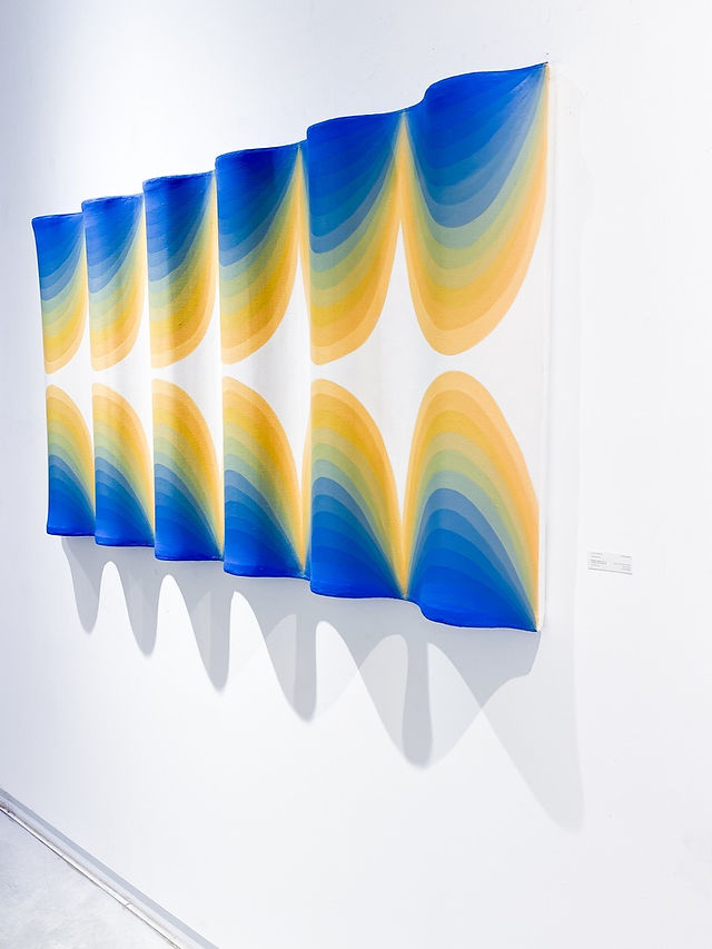 a large shaped canvas exploring light waves with a vibrant color gradient from light orange to blue by geometric artist, jessica moritz at wertheimer gallery