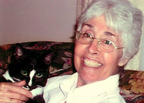 Woman holding a black and white cat.
