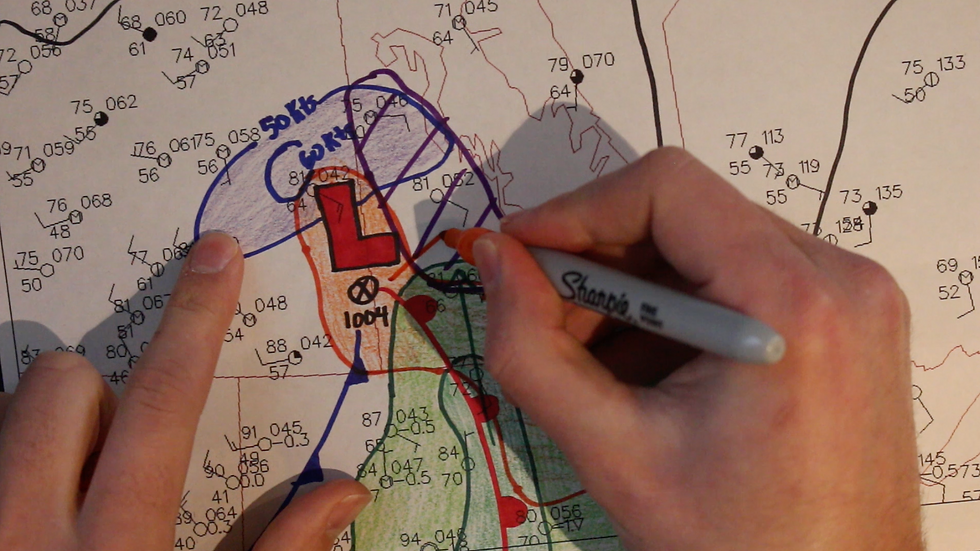 A trained meteorologist doing hand analysis on a surface weather map to determine where a tornado may occur in Manitoba on Aug 3, 2018 (Alonsa, MB EF4 tornado day).